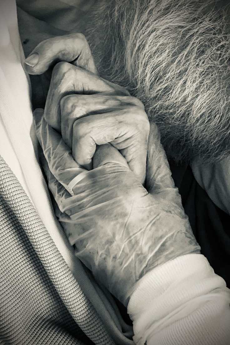 My father's hand holding my sister's finger