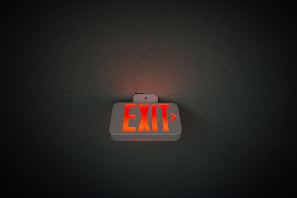 exit sign hanging on ceiling in public area